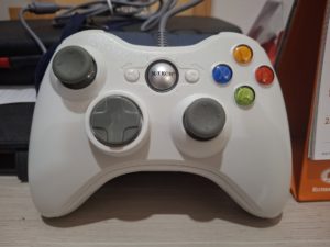 Manette de jeu Xbox 360 filaire posee sur fond blanc, le type de controleur gere par XInput 1.3