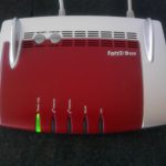 Routeur domestique posé sur un meuble, équipement qui fournit les serveurs DNS du réseau