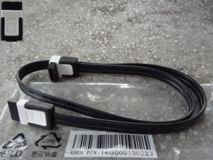 Cable de donnees SATA rouge pose a plat, connecteurs visibles aux deux extremites