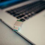 Cle USB metallique branchee sur le port lateral d un ordinateur portable ouvert, vue rapprochee