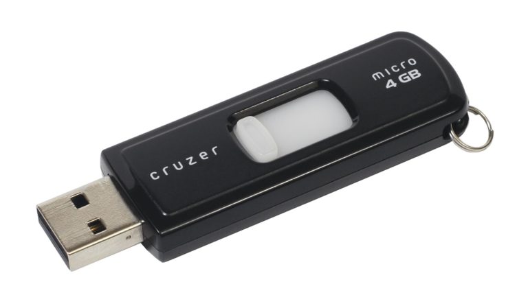Cle USB SanDisk Cruzer posee a plat sur fond blanc, capuchon retire et connecteur USB visible