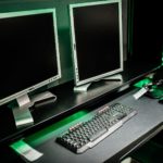 Configuration a deux ecrans posee sur un bureau, clavier et souris au premier plan