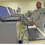 Technicien en cours de deploiement systeme sur des postes de travail, contexte de maintenance et de mise a jour