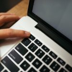 Main appuyant sur une touche de clavier de portable pour reveiller un ordinateur