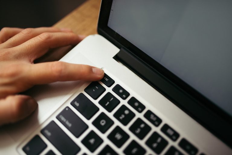 Main appuyant sur une touche de clavier de portable pour reveiller un ordinateur