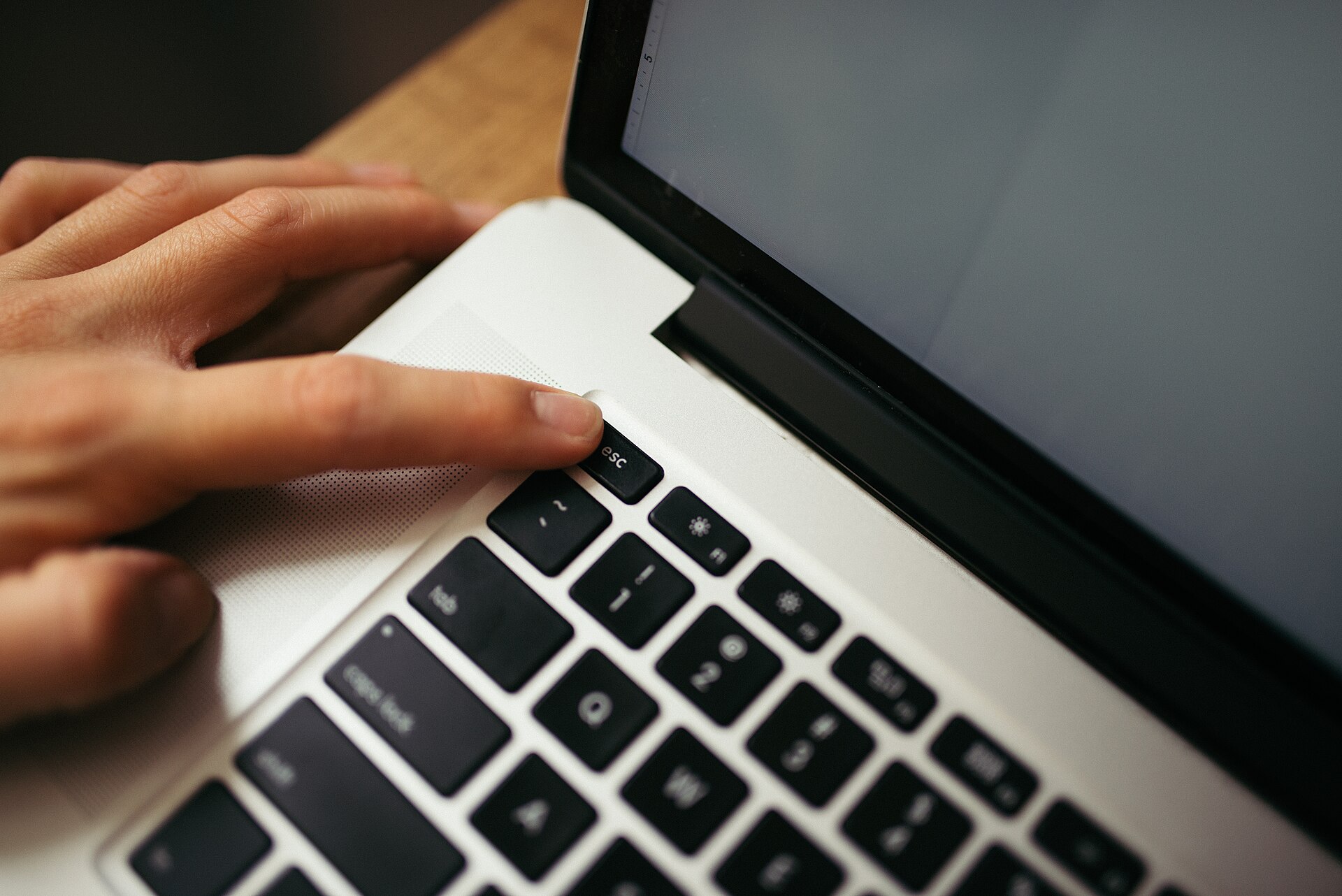 Main appuyant sur une touche de clavier de portable pour reveiller un ordinateur