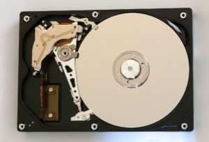 Intérieur d'un disque dur ouvert, plateau et bras de lecture visibles