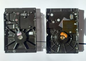 Disque dur mécanique ouvert montrant le plateau et le bras de lecture sollicités par les écritures