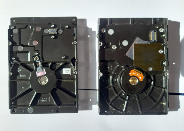 Disque dur mécanique ouvert montrant le plateau et le bras de lecture sollicités par les écritures