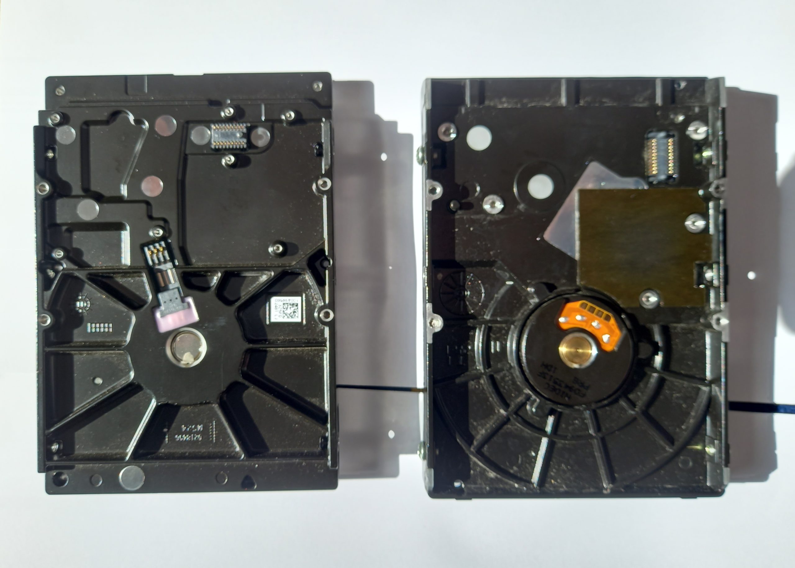 Disque dur mécanique ouvert montrant le plateau et le bras de lecture sollicités par les écritures