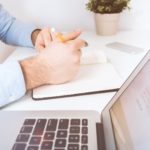 Porteur de projet qui prend des notes devant son ordinateur avant de lancer son projet web